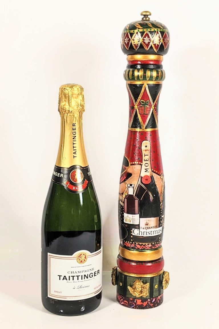 Picture of a hand-painted pepper mill standing next to a bottle of champagne to show siz